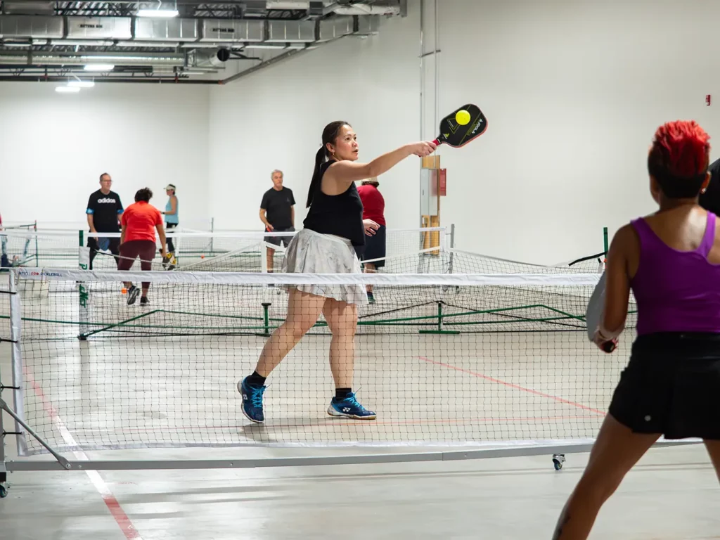 bower place indoor pickleball courts - woman taking a high shot